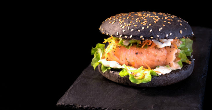 Black Burger mit Lachs, Guacamole, Mayonnaise und Salat. © iStockphoto.com/Yummy pic